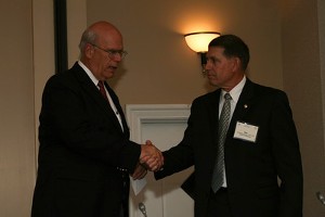 At the chapter's inaugural USMC IT Day in April, Mike Warlick (r), chapter president, presents Kent Schneider, president and chief executive officer of AFCEA International, with a scholarship check for $10,000.